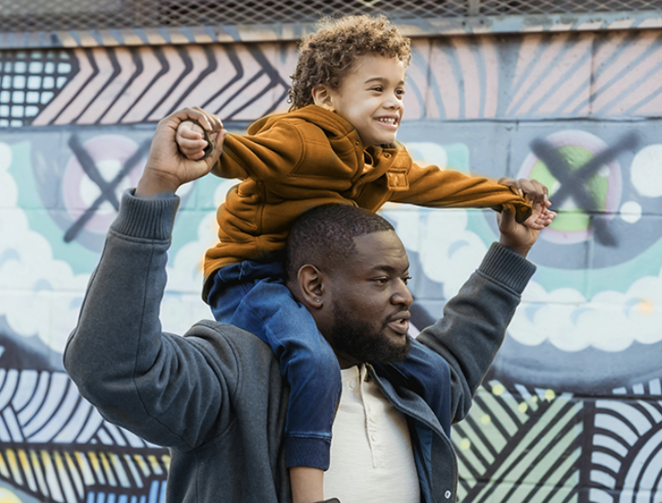 dad with young son on shoulders